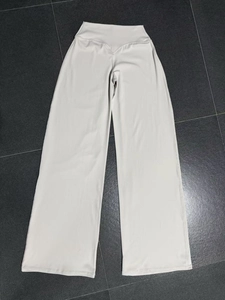 Detail einer cremefarbenen High-Waist-Yoga-Hose mit weitem Bein und V-förmigem Bund
