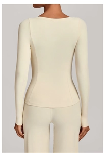 Détail d'une veste de yoga blanc crème avec coutures au dos et tissu élastique sport