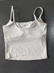 Detailed flat lay of white ribbed yoga crop top with square neck and thin straps