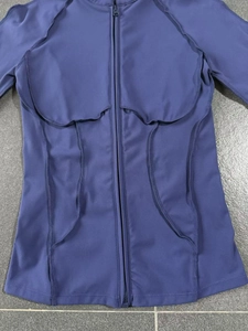 Vue détaillée de la veste de yoga violet foncé zippée avec coutures plates et tissu respirant