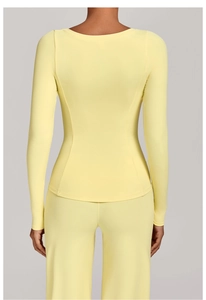 Vue arrière du haut de yoga jaune à manches longues avec coutures lisses et coupe ajustée