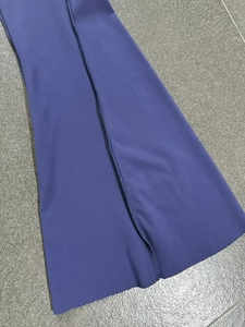 Detail of navy blue high-waisted yoga pants featuring a stylish side slit at the bottom hem