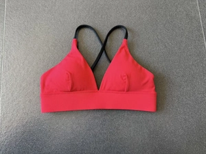 Detail von Sport-BH in Rot-Schwarz mit verstellbaren Kreuzträgern und breitem Unterband