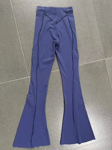 Macro detail of high-waisted flared yoga pants with stylish contrast stitching