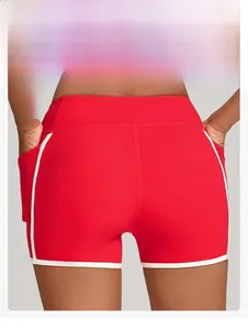 Gros plan sur le short de yoga rouge à rayures blanches et coutures galbantes pour le sport