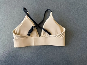 Detailansicht Sport-BH in Beige mit verstellbaren schwarzen Kreuzgurten und Metallschnallen