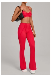 Détail d'un ensemble de yoga rouge avec haut à fines bretelles et pantalon de sport évasé
