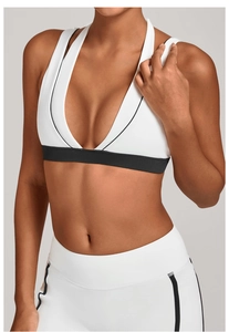 Vue détaillée du soutien-gorge de sport blanc élastique avec passepoil noir contrasté