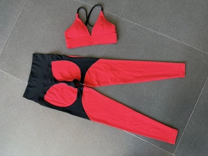 Flat lay of red and black two-piece yoga set with cross-strap bra and high waist leggings