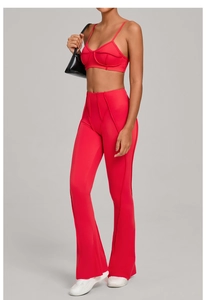 Détail d'un ensemble de yoga rouge avec surpiqûres sur le haut et pantalon à taille haute