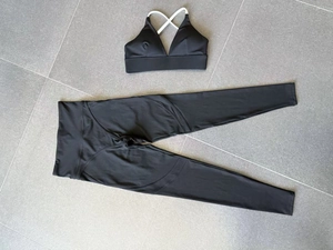 Flat lay of black yoga set with V-neck sports bra and high-waisted leggings