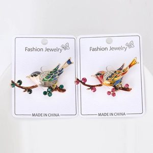 Détails de broches d'oiseaux en émail et cristaux sur cartes de présentation