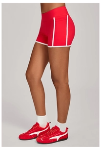 Détail du short de yoga rouge à taille haute avec poches latérales et bandes blanches contrastées