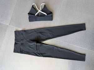 Detail of cross-strap sports bra and high-waist leggings with white contrast stitching