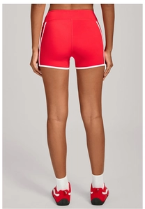 Détail du short de yoga rouge à taille haute avec passepoil blanc et tissu à séchage rapide