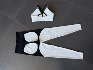 Detailed flat lay of two-piece yoga set with white sports bra and black paneling leggings