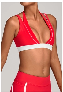 Détail du soutien-gorge de sport rouge avec col licou et finitions contrastées en blanc