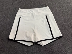 Détail d'un short de yoga blanc taille haute avec bordures noires et poches latérales