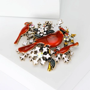 Détail de la broche oiseau cardinal rouge avec flocons de neige et strass colorés