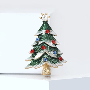 Broche sapin de Noël en émail vert avec strass colorés sur un piédestal blanc