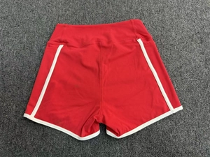 Vue à plat détaillée d'un short de yoga rouge à taille haute avec liseré blanc et poches latérales
