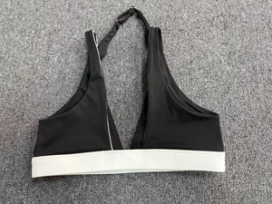 Soutien-gorge de sport dos nu contrasté noir et blanc posé sur un tapis gris texturé