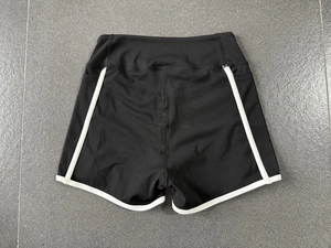 Vue arrière du short de yoga taille haute en tissu noir avec passepoil blanc contrasté