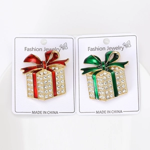 Detail of red and green enamel Christmas gift box brooches with sparkling rhinestones
