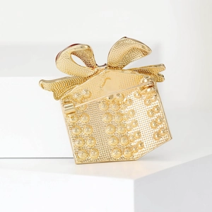Back view of gold enamel gift box brooch with secure pin clasp on a white stand