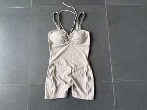 Vue à plat d'une combinaison de yoga abricot avec licou et poches latérales pratiques
