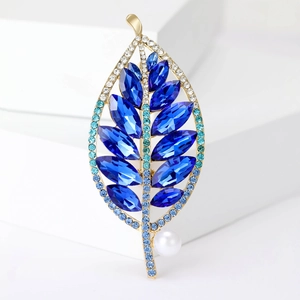 Elegante spilla a foglia dorata con cristalli blu intenso e un accento di perla bianca