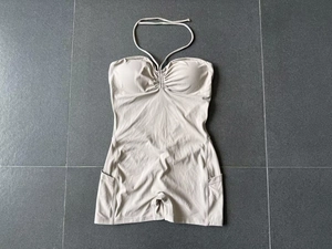 Détails d'un combishort de yoga côtelé beige avec poches latérales et design froncé