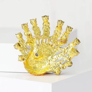 Broche paon dorée avec strass colorés sur un élégant socle d'affichage blanc minimaliste