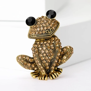 Détail d'une broche grenouille avec strass champagne et de grands yeux en gemme noire