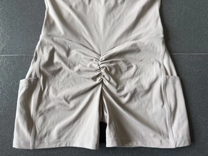 Détail d'une combishort de yoga beige avec effet push-up et poches latérales