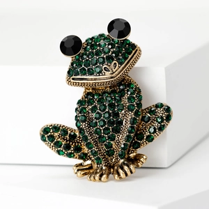 Détail d'une broche grenouille créative en strass verts avec alliage doré et yeux noirs