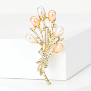Détails de la broche bouquet avec perles et cristaux sur une monture dorée