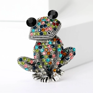 Vue détaillée d'une broche grenouille 3D sertie de strass colorés et gemmes noires