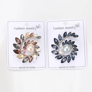 Dettaglio di spille ramo d'ulivo blu e marroni con strass marquise e perle lucide