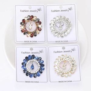 Macro detail of vintage alloy rhinestone floral brooches with water-drop pendants