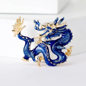 Exquisite blue enamel Chinese dragon brooch with gold accents on a geometric display