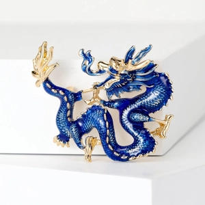 Detailed close-up of blue enamel and gold-plated scales on the dragon brooch