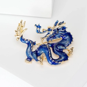 Detailed close-up of blue enamel dragon brooch with intricate gold plating and scales