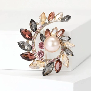 Elegante spilla a corona a spirale con cristalli colorati e una grande perla centrale