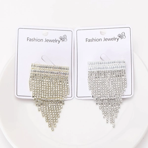 Vue détaillée des boucles d'oreilles à pompons en strass brillants en or et argent
