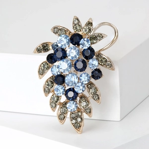 Vue détaillée d'une broche en forme de raisin en strass bleus et alliage doré