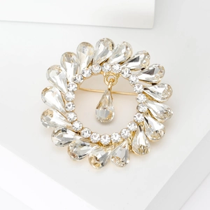 Macro shot of gold floral wreath brooch with sparkling waterdrop crystals and rhinestones