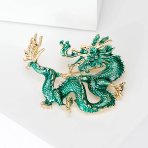 Elegant gold-plated Chinese dragon brooch with deep green enamel on white background