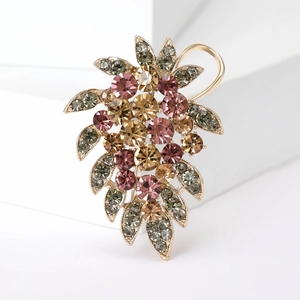 Gros plan d'une broche feuille élégante sertie de strass roses et champagne étincelants
