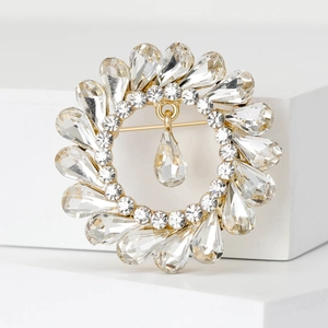Detailed macro view of vintage round rhinestone brooch with a hanging pear-cut crystal pendant